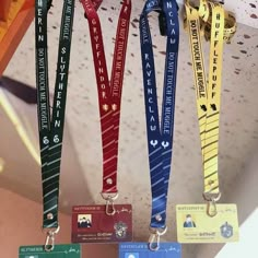 four lanyards with name tags hanging from the ceiling in front of other lanyard items