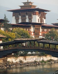 a bridge over a body of water in front of a large building with many windows