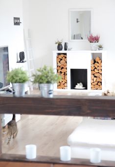 a living room filled with furniture and a fire place in front of a fireplace covered in logs