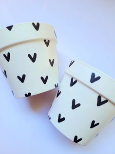 two white cups with black hearts on them