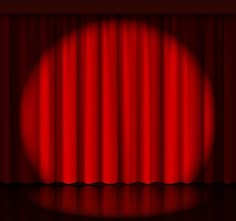 a red curtain with the light shining down on it's surface, in front of a dark background