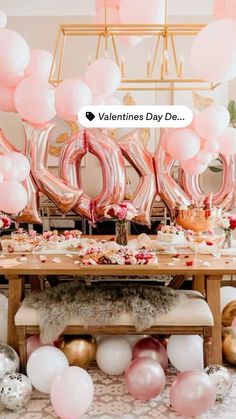 a table topped with balloons and pink letters