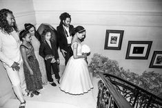 a bride and groom are walking down the stairs with their guests in black and white