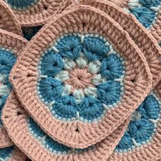 crocheted coasters are arranged on top of each other in blue and pink