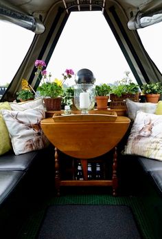 the inside of an airplane with plants and flowers on it's windowsills