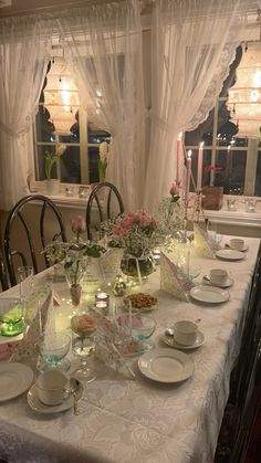 the table is set with plates, cups and saucers