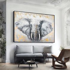 an elephant painting hanging on the wall above a gray couch in a white living room