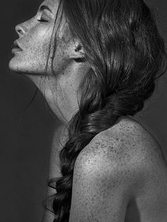 a black and white photo of a woman with freckles on her back neck