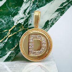 "This exquisite pendant, crafted in 14k yellow gold, is a perfect addition to your jewelry collection. The pendant features an encrusted diamond initial \"D\" that adds a touch of elegance to any outfit. The round shape of the pendant is classic and timeless, making it a versatile piece that can be worn on any occasion and with different chains of your own . Total weight 1.8gr, diamond weight 0.10ct" Luxury Gold Round Initial Necklace, Yellow Gold Initial Necklace With Round Pendant, Luxury Gold Initial Necklace, Yellow Gold Round Initial Necklace With Diamond Accents, Gold Pendant Initial Necklace With Diamond Accents, Gold Initial Necklace With Diamond Accents, Hamsa Pendant, Star Of David Pendant, Initial D