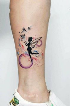 a woman's leg with a tattoo on it that has a fairy and butterflies