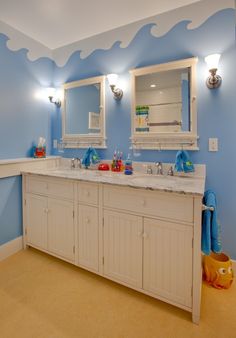 a blue and white bathroom with two sinks