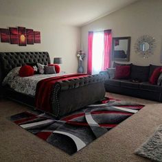 a bedroom with a bed, couch and rugs in front of a window that has red curtains