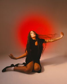 a woman with long hair sitting on the floor