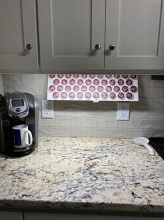 a kitchen counter top with a coffee maker and paper towels hanging from it's holder