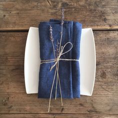 a white plate topped with blue napkins covered in lavender