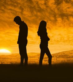 two people are walking in the field at sunset or sunrise with their backs to each other