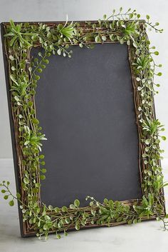 an old photo frame decorated with greenery