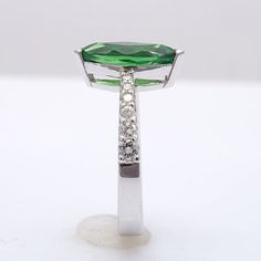 Set within an 18K white gold ring, this 2.29 carat Tsavorite, has a lush vivid green color. Known for their small sizes, the cutter has gained maximum from the rough, establishing a perfect marquise. Highlighted by the graduating diamond accents on either side of the tapered band, it is the perfect ring for delicate fingers. Order online info@jupitergem.com Green Oval Diamond Ring With Vvs Clarity, Modern Green Diamond Wedding Ring, Green Oval Diamond Ring In Sterling Silver, Oval Tsavorite Diamond Ring In Green, Oval Green Tsavorite Diamond Ring, Gia Certified White Gold Tsavorite Rings, Modern Green Diamond Anniversary Ring, Green Brilliant Cut Emerald Ring In Sterling Silver, Green Emerald Ring With Brilliant Cut In Sterling Silver