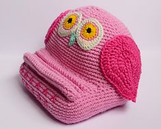 a pink knitted hat with an owl on it