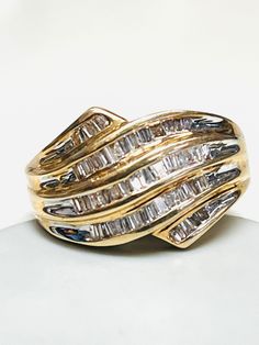 a gold ring with three rows of baguettes on it's sides, set against a white background