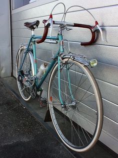 a blue bicycle parked next to a garage door