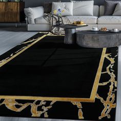 a black and gold rug in the middle of a living room with white couches