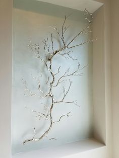 a white vase sitting on top of a shelf in front of a window sill