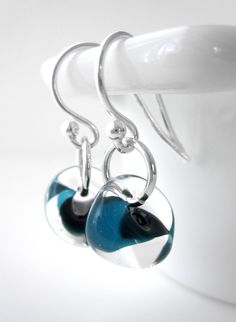 Perfectly petite everyday wear earrings. Beautiful, watery, molten glass is 'wrapped' to create a little free-form drop with dark aqua wisps of color. A simple, elegant presentation: a sterling silver ring is slipped through the opening in the glass and elegantly suspended from sterling silver French earrings hooks. Perfectly petite at approx. 1" total length -- everyday wearable! Small glass drops: approx. 8mmx 10mm x 10mm each (5/16" wide x 3/8" deep x 3/8" tall each) Length: approx. 1" total length All metal is sterling silver French Earrings, Simple Silver Earrings, Blush Earrings, Silver Bridal Earrings, Simple Gold Earrings, Gold Round Earrings, Dark Aqua, Elegant Presentation, Raw Stone Earring