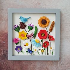 a shadow box with flowers and a bird in it