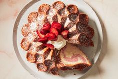 a white plate topped with strawberry shortcakes covered in powdered sugar and sliced strawberries