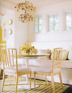 a dining room with yellow walls and white furniture