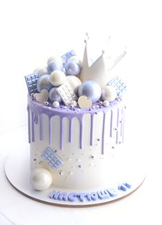 a white cake with purple icing and decorations