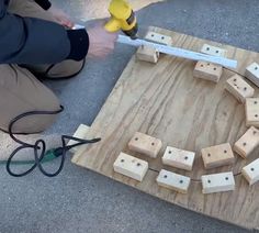 a person using a power tool to cut wood blocks