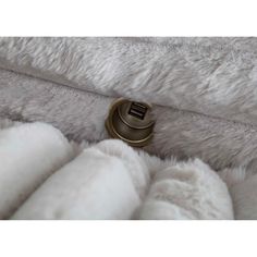 a close up view of a white blanket with a button on the bottom and some fur around it