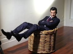 a man sitting in a basket on the floor