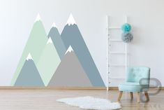 a living room with a chair and mountain wall decal