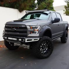 a grey truck parked in front of a white wall