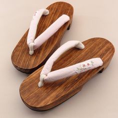 These wooden sandals are called "Geta" in Japan. They have been around for over 1,300 years and were originally worn with traditional Japanese clothing like kimonos and yukatas. Recently, Geta sandals have become popular as fashion items, thanks to modern updates in the shape and color of the wooden base, as well as the materials and patterns of the straps. Product Details - Product ID: 10007-027 - For: Women - Condition: New - Color: Pink tones - Brand: Kimono Avenue - Place of origin: Made In Geta Sandals, Traditional Japanese Clothing, Embroidery Green, Chinese Shoes, Japanese Clothing, Wooden Sandals, Cute Shoes Heels, Shoes Teen, Vintage Inspiration