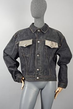 Features: - 100% Authentic JEAN PAUL GAULTIER. - Distress black denim jacket. - Silver metal plates on the front flap pockets . - Full long sleeves and button up closures. - Label reads: JUNIOR GAULTIER JUNIOR Size L. - Two missing screws on one metal plate, doesn't detract from its beauty. - Very good vintage condition. Measurements taken laid flat, please double bust and waist: Shoulder: 22.05 inches (56 cm) Sleeves: 24 inches (61 cm) Bust: 24 inches (61 cm) Waist: 20.86 inches (53 cm) Length: Black Denim Jacket With Multiple Pockets, Black Denim Jacket With Flap Pockets, Edgy Denim Jacket With Pockets For Work, Edgy Denim Jacket With Button Closure, Vintage Jean Paul Gaultier, Vintage Versace, Metal Plates, Black Denim Jacket, Christian Lacroix