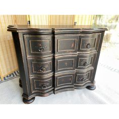 an old black dresser with drawers and knobs