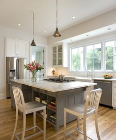 a large kitchen with an island and two chairs