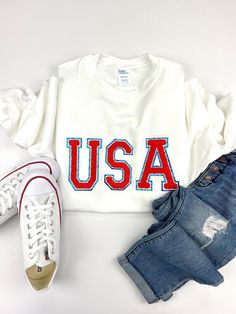 Show off your love for home and country this summer!  You can be cute, patriotic and warm this summer while you sit by the campfire and spend time under the stars!  This super cute sweatshirt features patriotic red, white and blue USA chenille patches. Select from 4 different adult shirt styles, or kids sizes! We stock unisex crew-neck tees, women's v-neck shirts, flowy tank tops, and unisex sweatshirts for adults, in a variety of colors. We custom design, print, and carefully ship everything yo White Crew Neck Sweatshirt For 4th Of July, Patriotic Letter Print Sweatshirt For Independence Day, Patriotic White Cotton Sweatshirt, Casual Letter Print Sweatshirt For Independence Day, Independence Day Casual Letter Print Sweatshirt, Independence Day Cotton Letter Print Sweatshirt, Independence Day Cotton Sweatshirt With Letter Print, Independence Day Letter Print Sweatshirt, Patriotic Crew Neck Sweatshirt For Independence Day