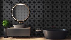 a black and white bathroom with an oval mirror above the bathtub next to a sink