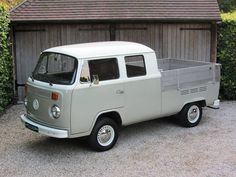 an old white truck parked in front of a wooden building with ivy growing around it