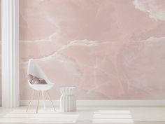 a pink marble wallpaper in an empty room with a white chair and side table