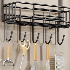 kitchen utensils hanging on the wall next to a rack with scissors and spatulas