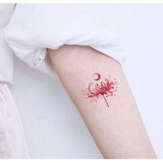 a woman's arm with a red flower tattoo on the left side of her arm