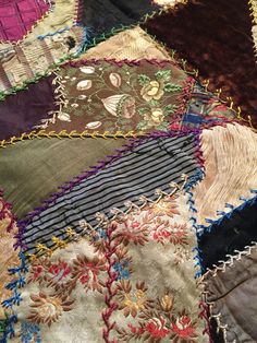 an old quilt with many different colors and designs on it's edges, including flowers