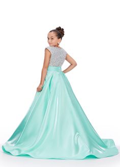 This Ashley Lauren girls' ballgown features a luxurious satin fabric, a stunning stone-encrusted bodice, and a bow at the waistline for a touch of elegance. Perfect for special occasions, this gown will make any young girl feel like a princess. Sparkle and sophistication meet in this beautifully designed dress. Colors: Peacock, Aqua, White Sizes: 4-16 Princess Style Satin Ball Gown For Pageants, Satin Ball Gown Pageant Dress, Princess Style Evening Dress For Prom Season Pageants, Floor-length Satin Dress For Quinceanera, Satin Gown For Pageant, Princess Evening Dress With Fitted Bodice For Pageant, Princess Style Evening Dress With Fitted Bodice For Pageants, Satin Floor-length Gown For Pageant, Floor-length Satin Dresses For Pageants