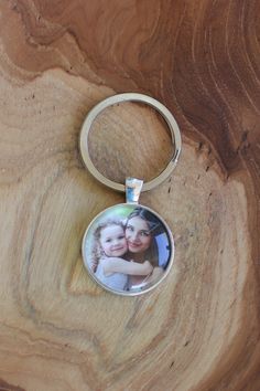 a keychain with a photo on it sitting on top of a wooden table